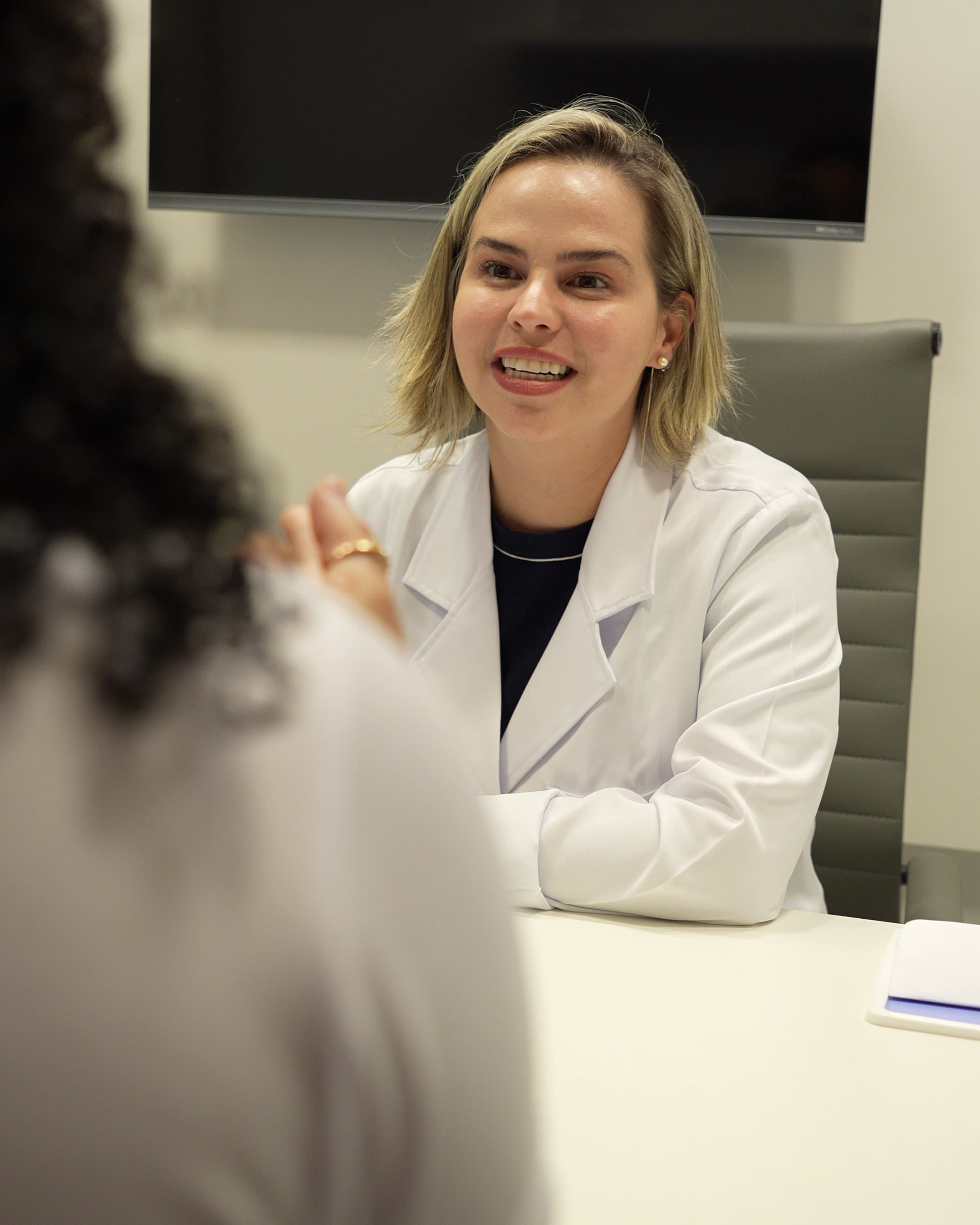 Fonoaudióloga da Maví sorrindo durante atendimento a uma paciente