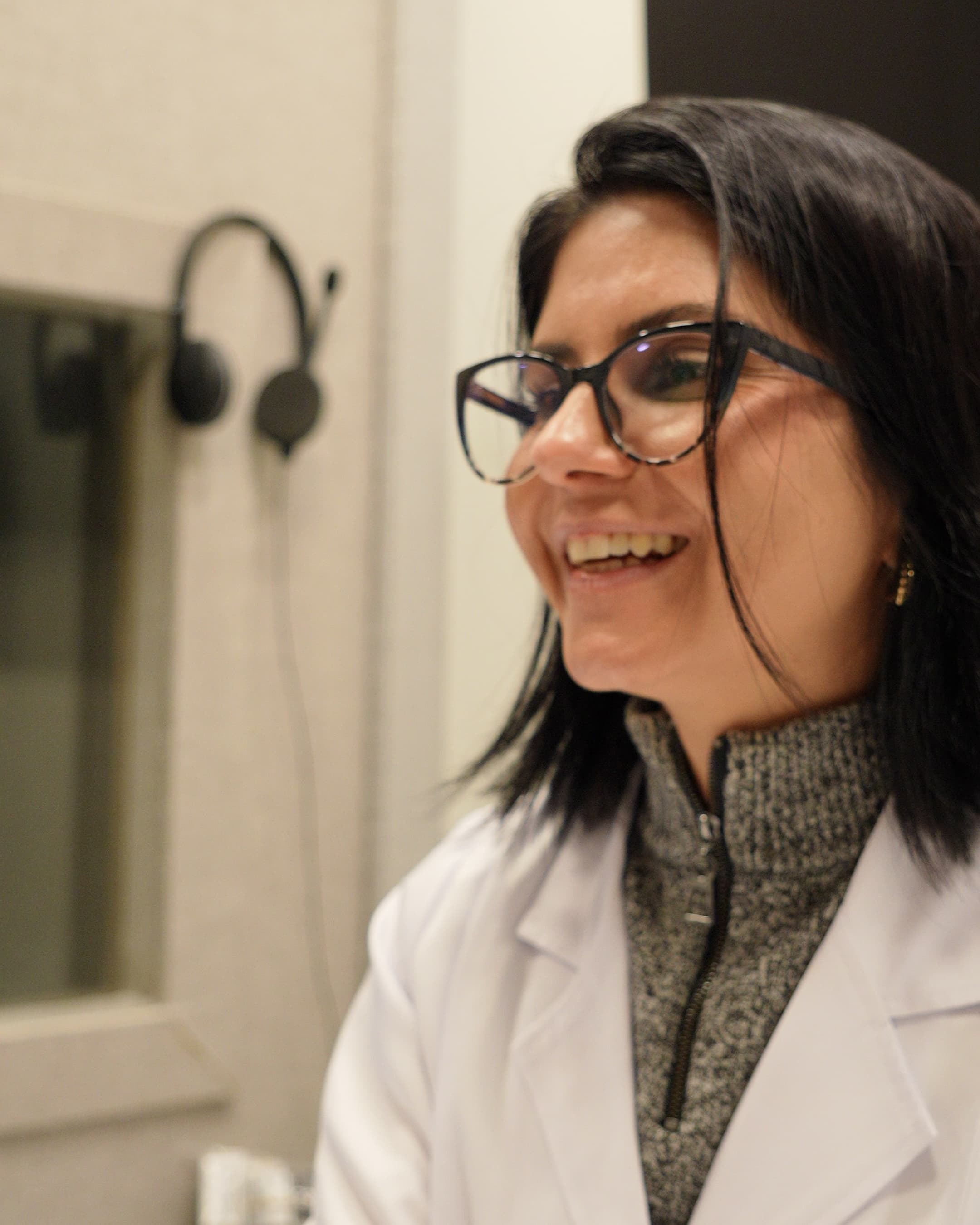 Fonoaudióloga da Maví sorrindo durante avaliação auditiva no consultório