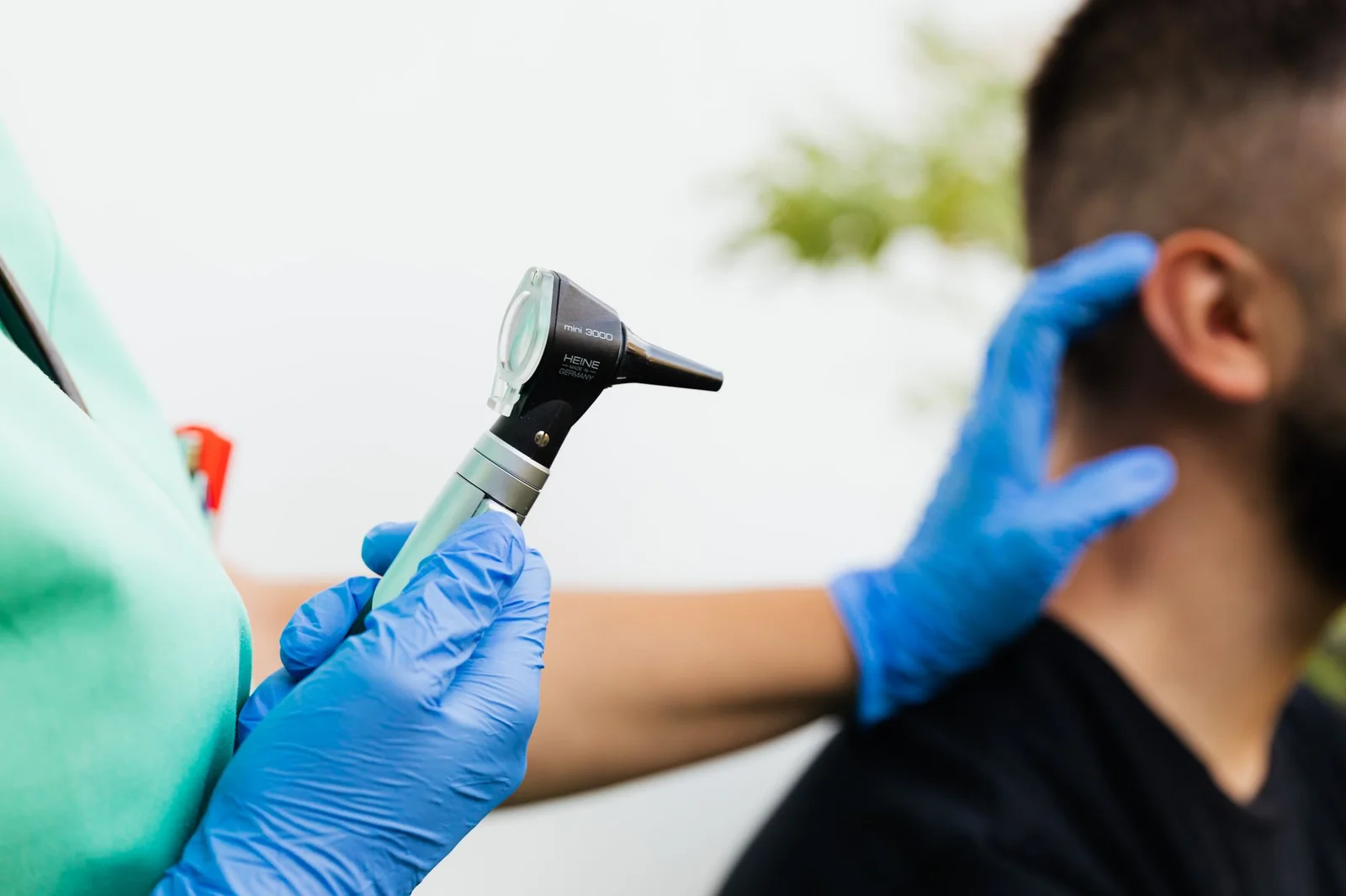 Profissional conduzindo teste auditivo em consultório. Foto de Kaboompics via Pexels.